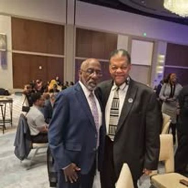 Two men in suits posing at a formal event.