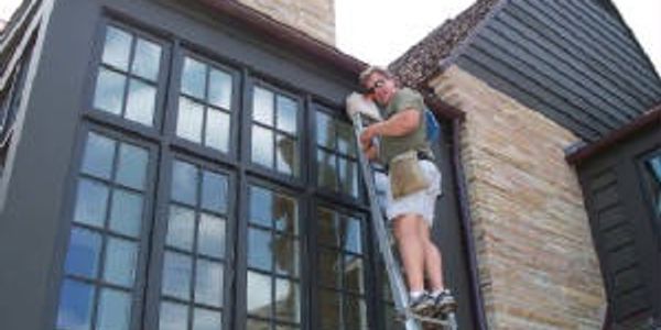 window cleaner on ladder cleaning french window panes