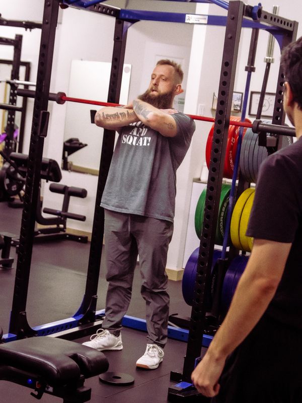 Man preparing to lift weights in a gym squat rack.