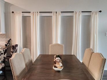 Elegant dining room with beige chairs and a wooden table centerpiece.