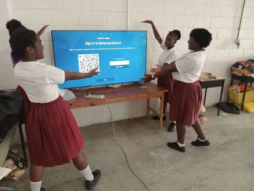 Image of excited music students showing off their new large screen TV.