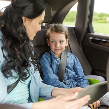 Mother and child seated safely in back of Hove airport taxi