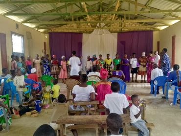 Children and adults gathered in a church hall for a community event.