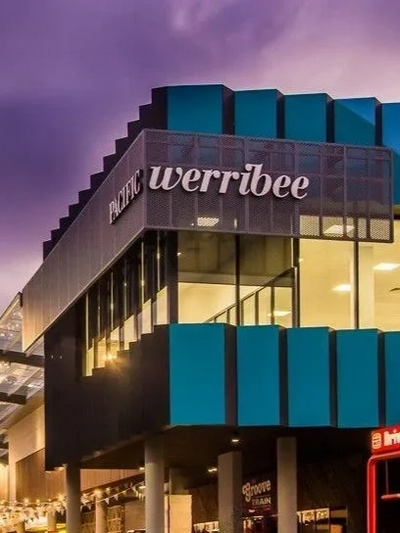 Modern building of Pacific Werribee shopping center at dusk.