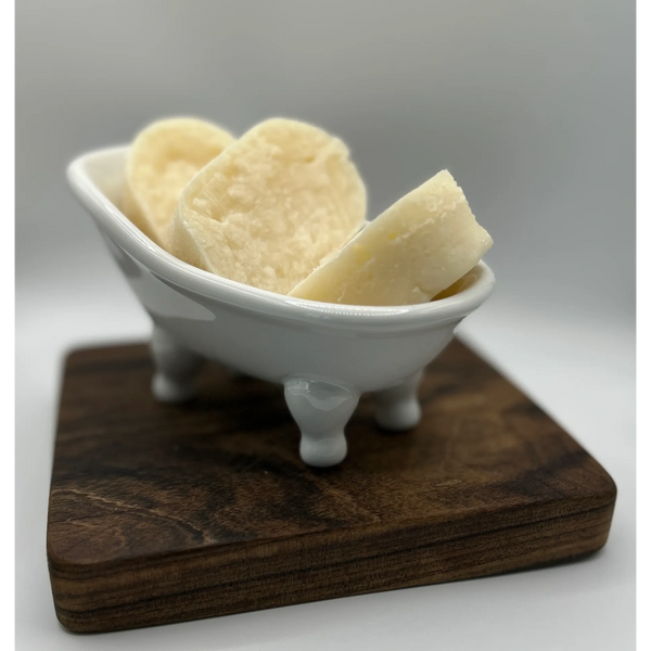 Slices of bread in a miniature white bathtub on a wooden board.