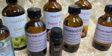 Various amber bottles of fragrance oils arranged on a floral fabric background.