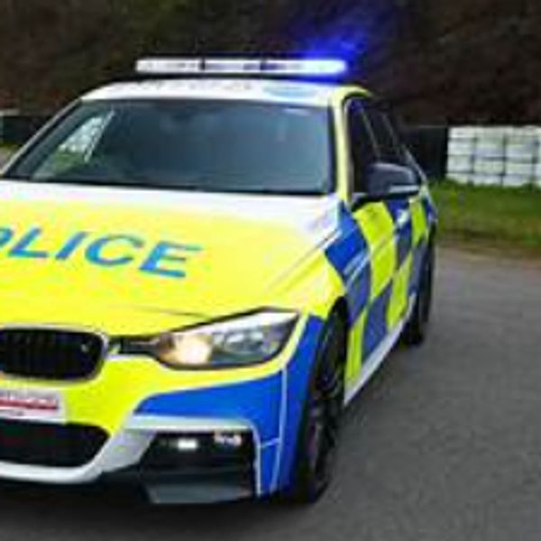 A police car with flashing blue lights and open driver door.