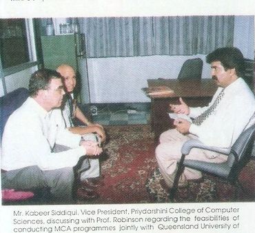 Three men discussing MCA program collaboration between Priydarshini College and Queensland University.