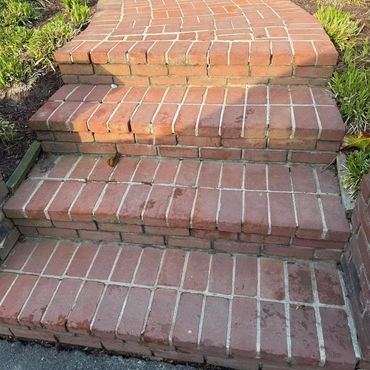 Brick walkway steps with worn joints down to a driveway, Richmond VA – before