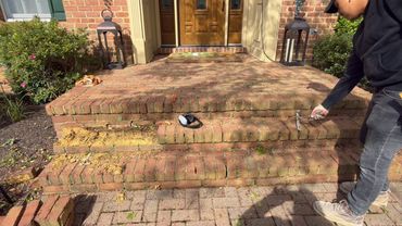Mason checking worn brick front steps and landing, Richmond VA – before