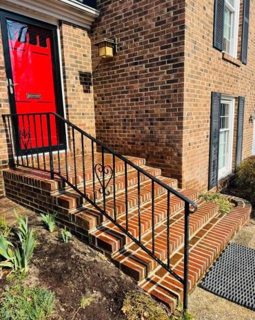 Brick front steps rebuilt with an iron railing at a red door, Richmond VA – after