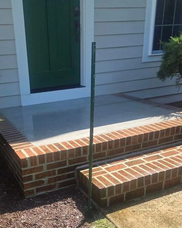 Brick steps rebuilt with a concrete landing at a green door, Richmond VA – after