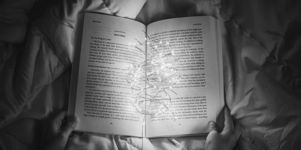 Black and white photo of a book with a flower outline overlay.