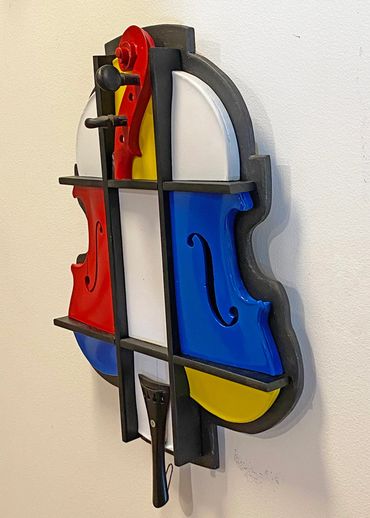 Side view showing the depth of a 3D cubist violin sculptured with a Mondrian-like color scheme.