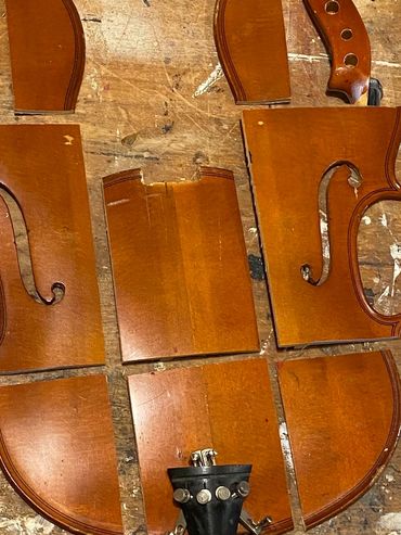 Antique violin parts have been cut prior to forming a 3D sculptured musical assemblage.