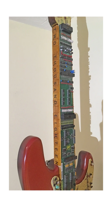 Guitar neck comprised of found electronic parts, wood, and scrabble letters