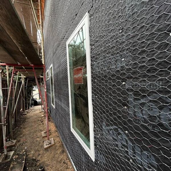 Construction site with windows with lath and wire mesh on the wall.