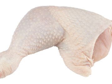 Raw chicken leg quarter with skin on isolated on white.