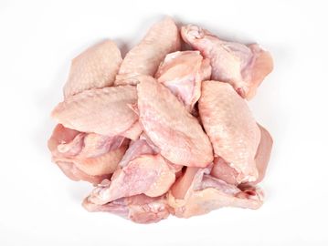 A pile of raw chicken wings on a white surface.