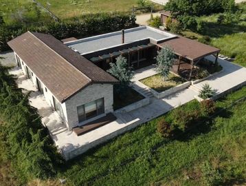 Modern single-story house with a large patio and landscaped garden.