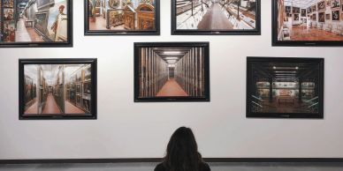 Person viewing framed photos in an art gallery.