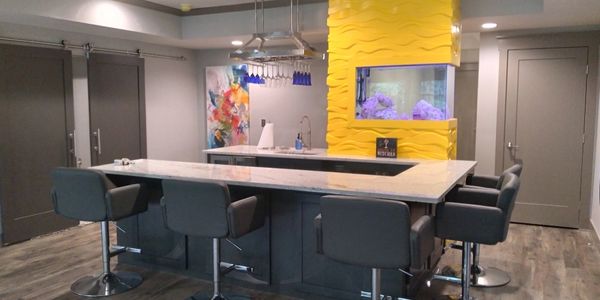 Finished basement in Douglasville, GA, featuring a custom bar with a saltwater aquarium.