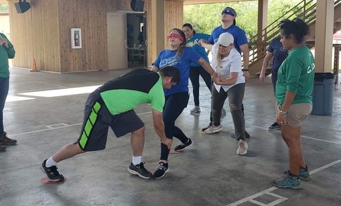 Adults participating in a team building exercise at camp.