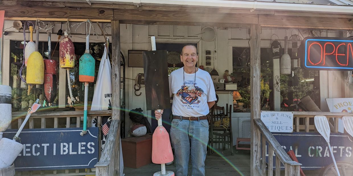 Close up of David, owner of Maggies Bygones antique and collectibles store, standing in front of ent