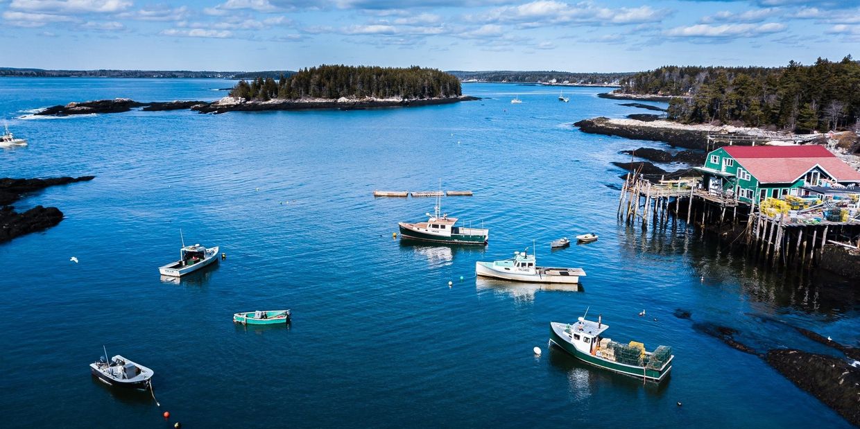 Aerial of North Cove Lobster, Phippsburg, Maine showing river, fishing boats, wharf, and islands / A