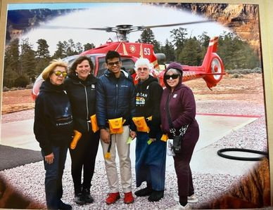 a group of people standing in front of a helicopter