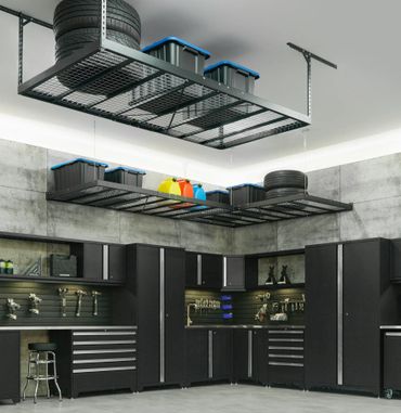 Modern garage with black cabinets and ceiling storage for tires and bins.
