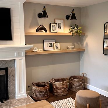 Cozy corner with wooden shelves, woven baskets, and a round stool in a warm living room.