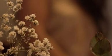 Close-up of delicate white baby's breath flowers with a warm, blurred background.
