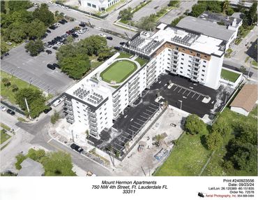 Aerial view of Mount Hermon Apartments with parking and green rooftop area.