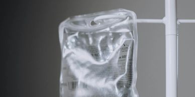 Close-up of a clear intravenous (IV) fluid bag hanging on a stand.