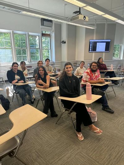 Students smiling and sitting in a classroom.