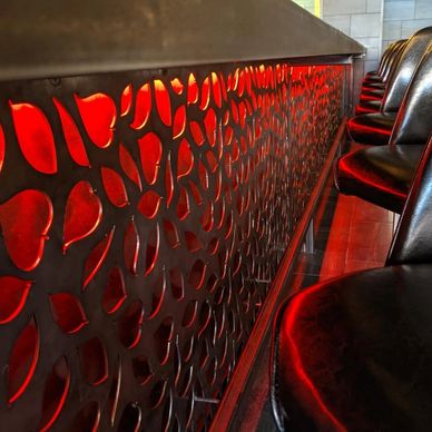Row of black leather seats beside a decorative red-lit panel.