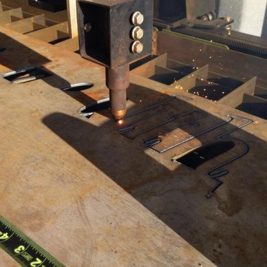CNC plasma cutter slicing through metal sheet.