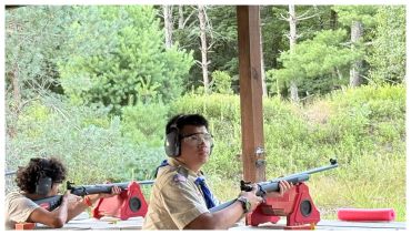 Two people shooting rifles at a range.