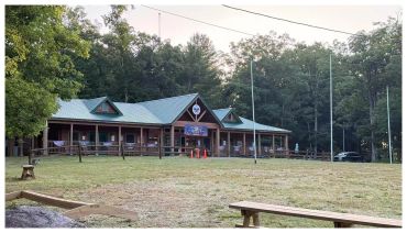 A rustic camp lodge surrounded by trees.
