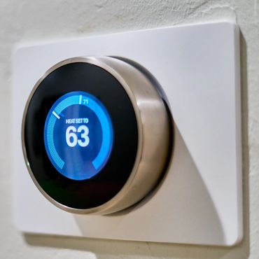 Smart thermostat set to 63 degrees Fahrenheit.