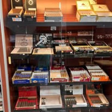 A glass display case filled with various cigar boxes and accessories.