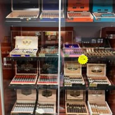 Display of various cigar boxes in a glass cabinet.