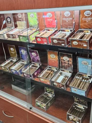 Display case filled with various flavored cigars in colorful packaging.