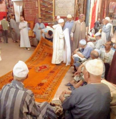 Buying rugs at rug auction in Marrakech, Morocco