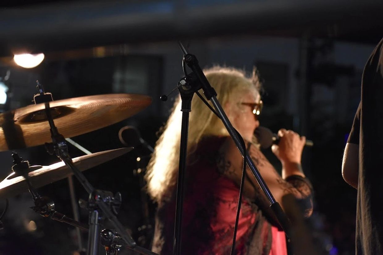 Blonde singer performing with microphone on stage.