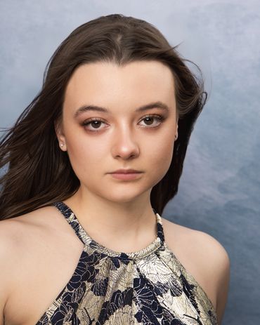 Headshot of young dark haired brown-eyed actress