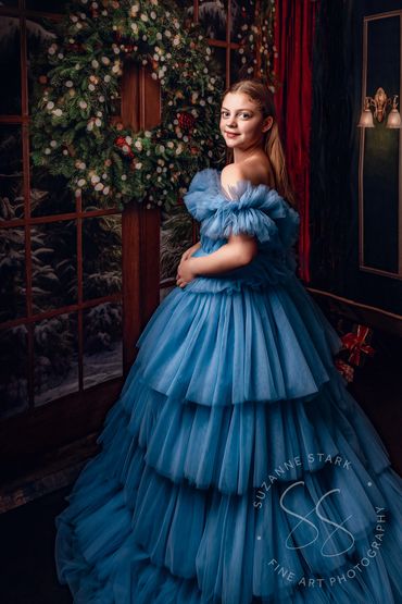 Painterly portrait of teen girl in blue off-the-shoulder couture gown near Christmas wreath