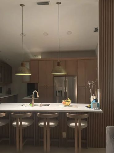 Modern kitchen with wooden accents and pendant lights over the island.