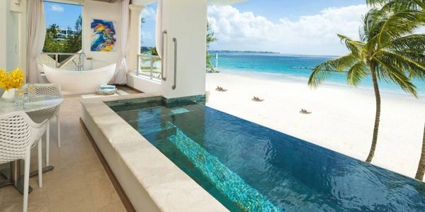 Luxurious beachfront suite with private pool, elegant bathtub, and stunning ocean view.